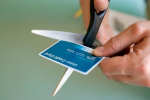 Hands cutting credit card with scissors